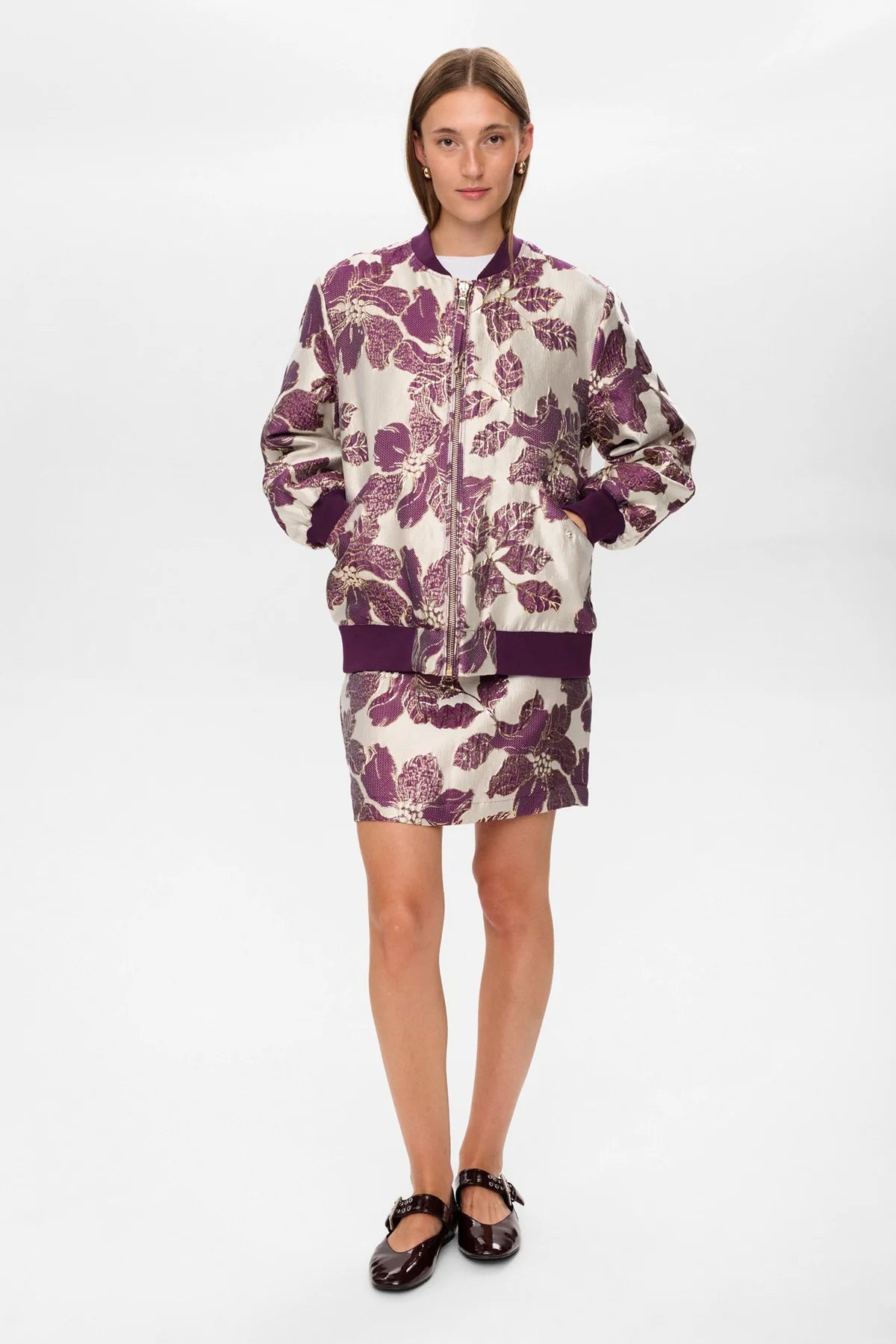 Person wearing a floral jacket and skirt set on a white background
