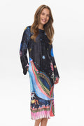 Woman wearing a colorful dress with abstract patterns on a white background