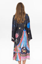 Woman wearing a colorful, patterned dress with a white background