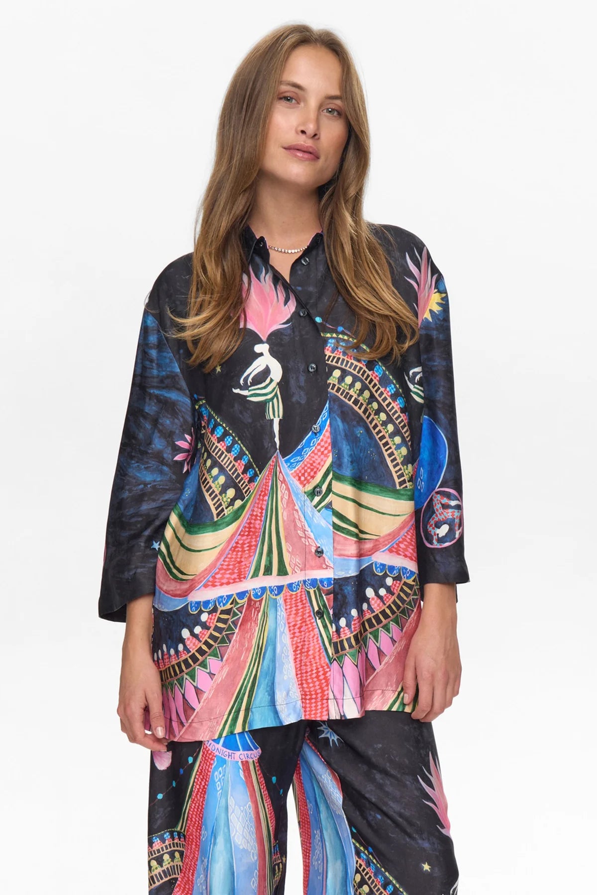 Woman wearing a colorful patterned shirt with a white background