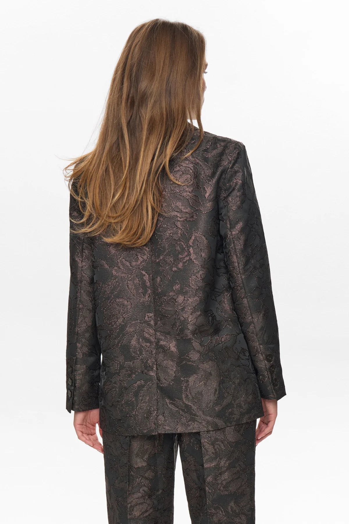 Woman wearing a patterned suit on a white background