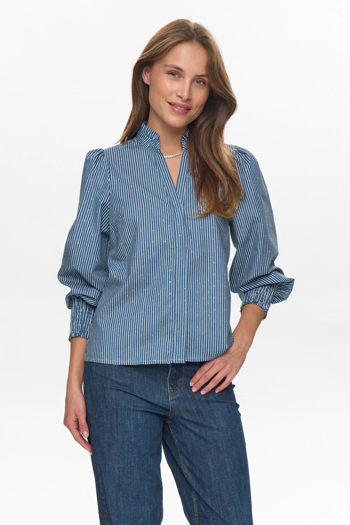 Woman wearing a blue striped shirt and jeans on a white background