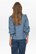 Person wearing a blue striped shirt and jeans on a white background