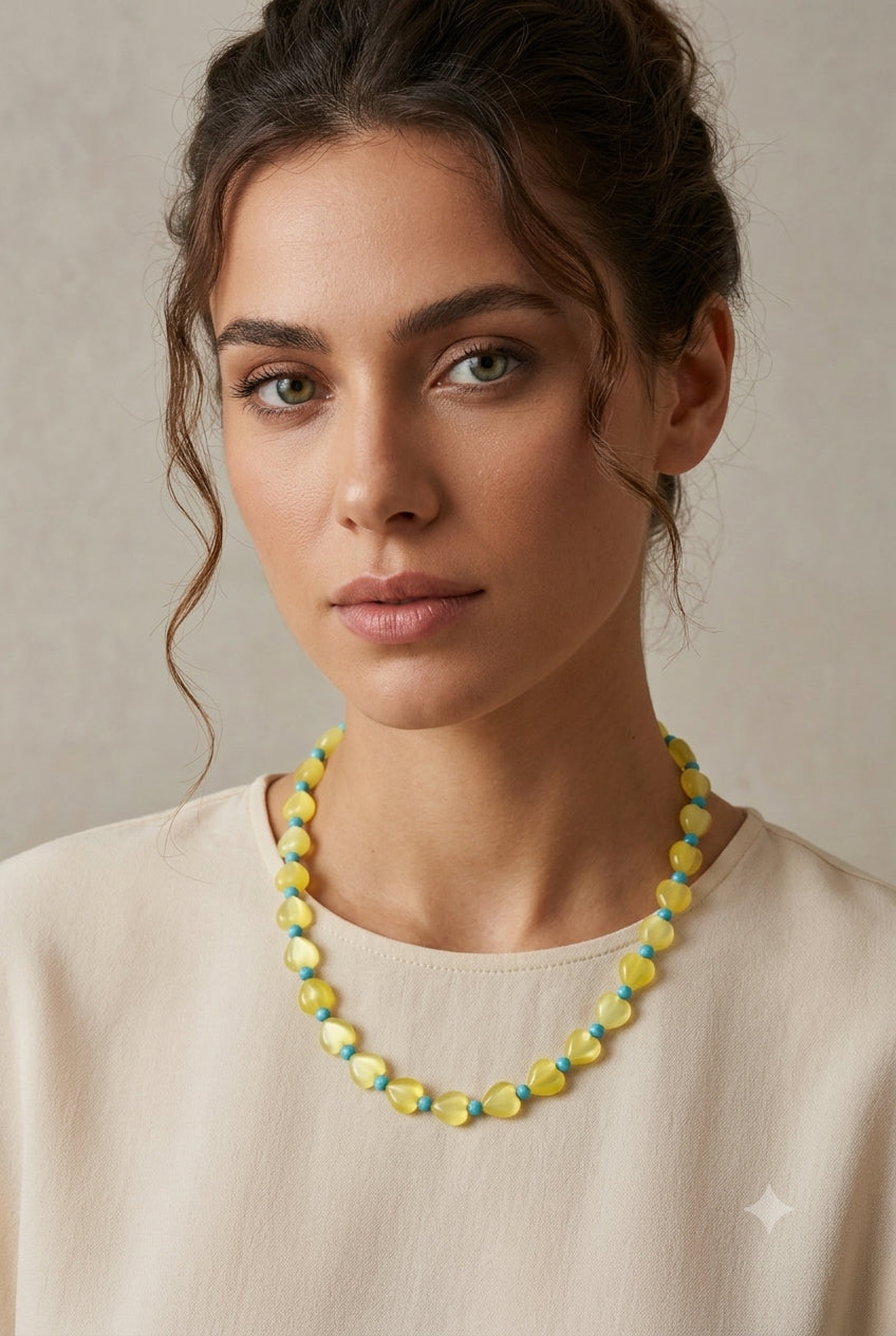 Woman wearing a colorful beaded necklace against a neutral background