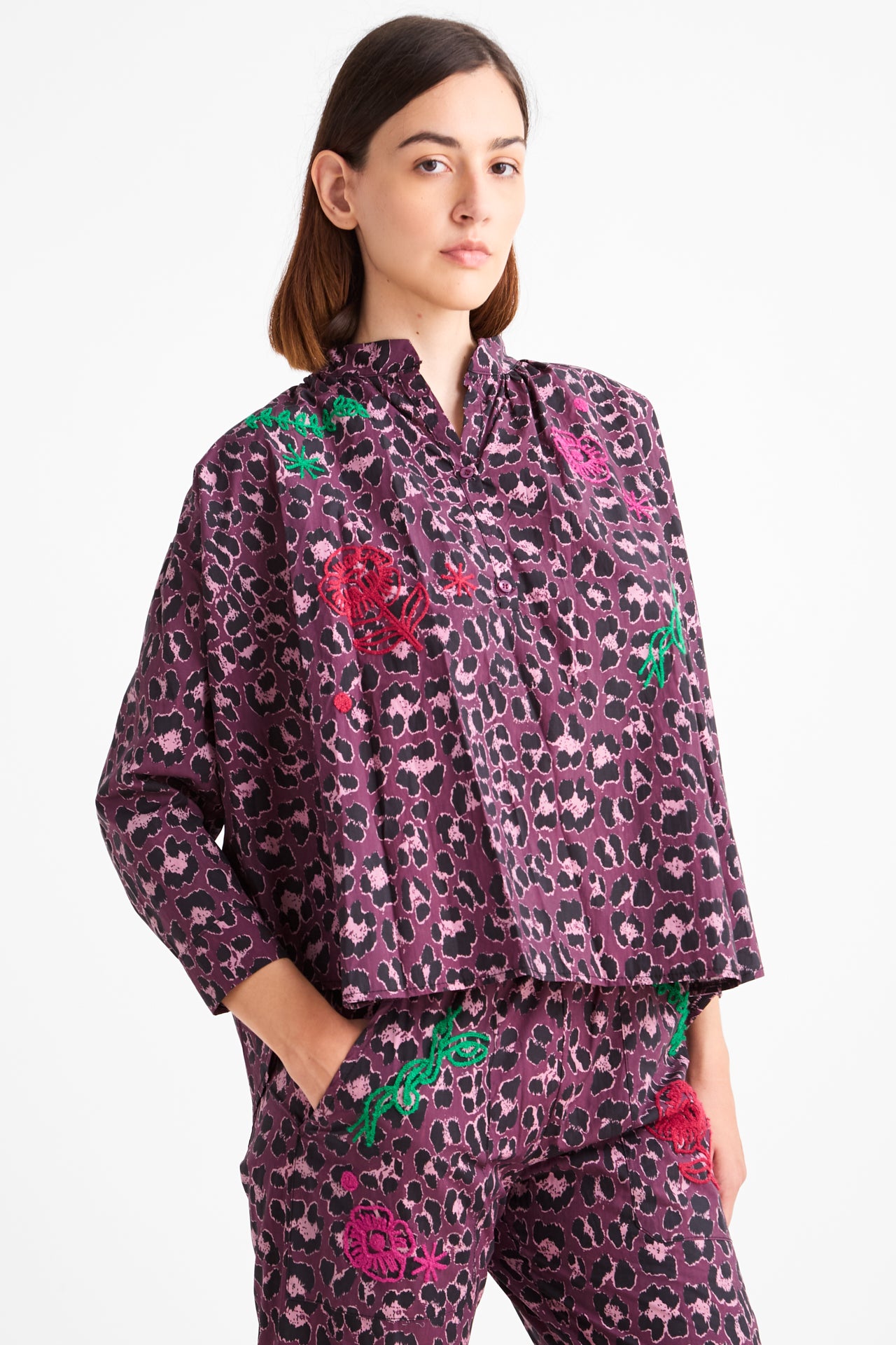 Woman wearing a purple patterned outfit on a white background