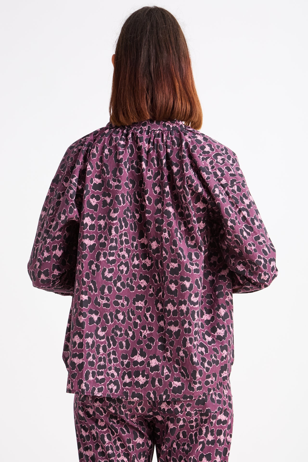 Person wearing a purple leopard print outfit on a white background
