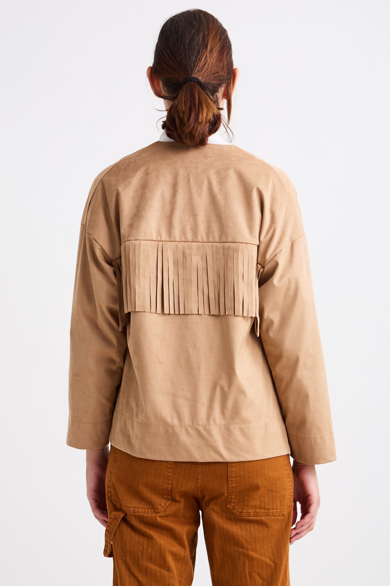 Person wearing a beige jacket with fringes on a white background
