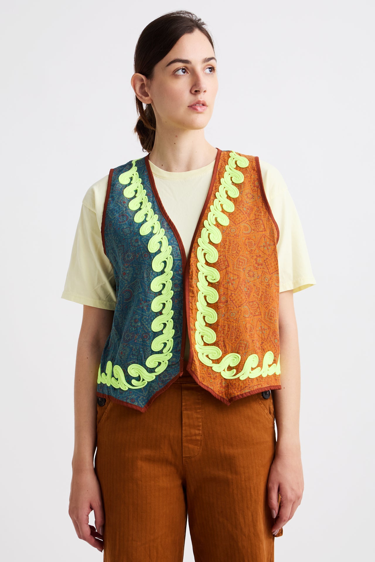 Person wearing a colorful knitted vest with a white background