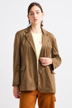 Person wearing a brown jacket over a yellow shirt on a white background