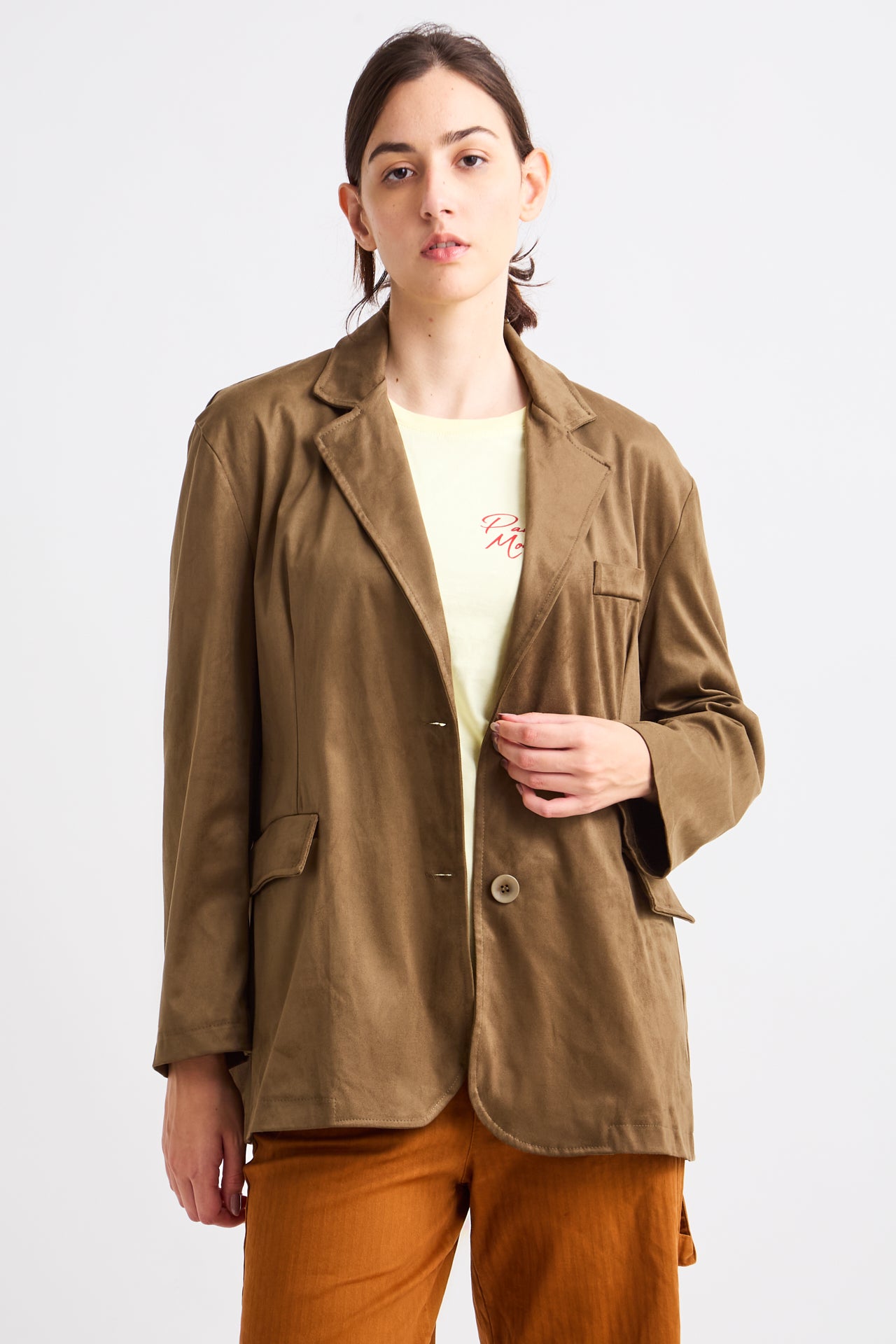 Person wearing a brown jacket over a yellow shirt on a white background