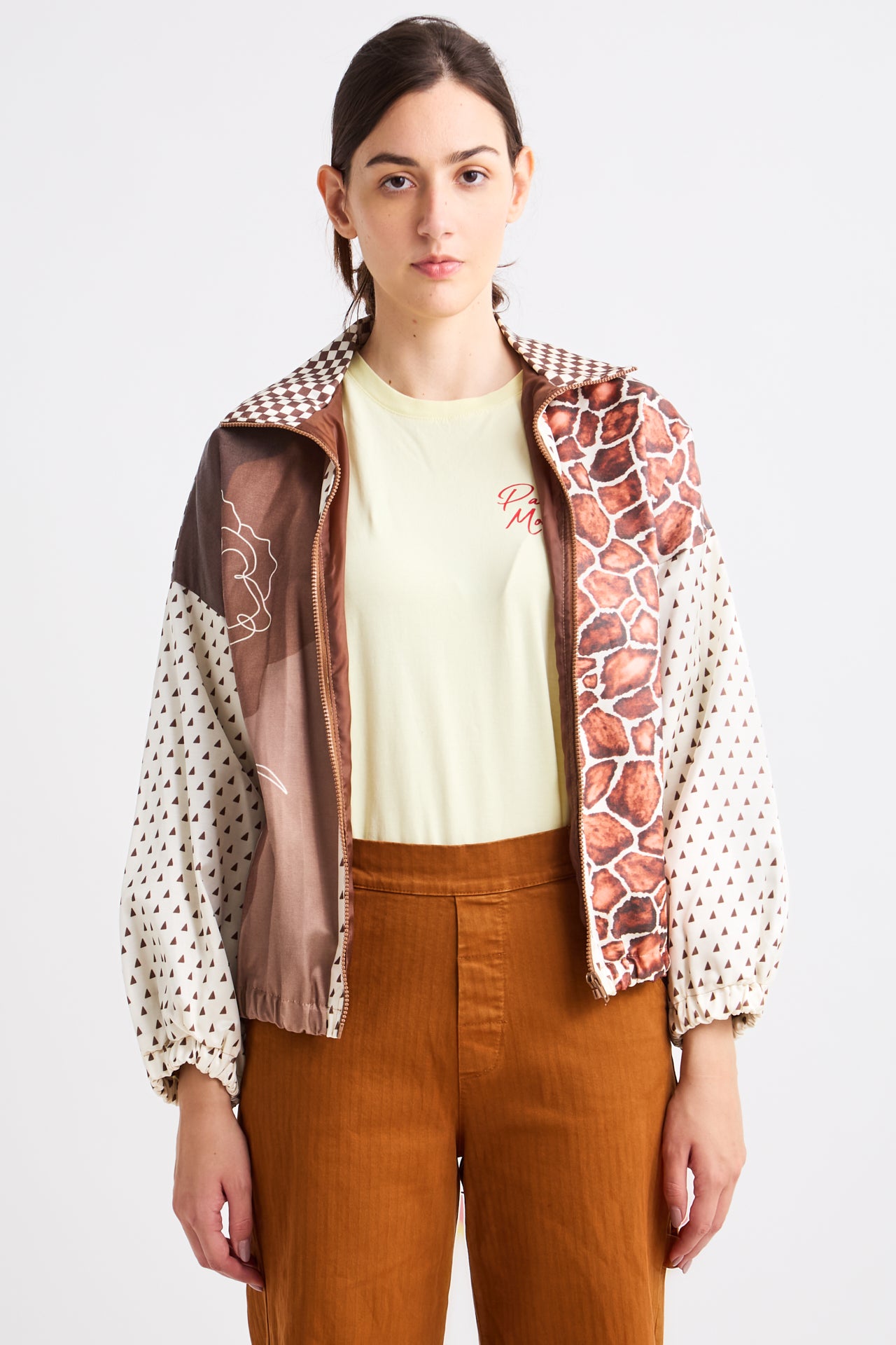 Person wearing a patterned jacket over a plain shirt with a white background