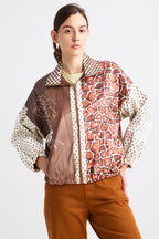 Person wearing a patterned jacket with a mix of colors on a white background