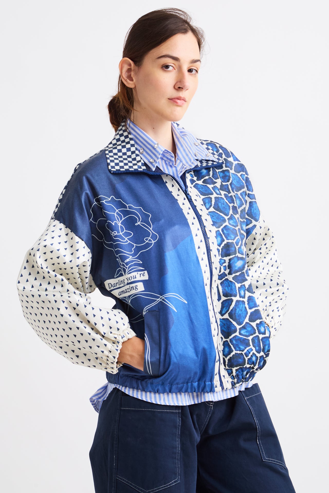 Person wearing a blue and white patterned jacket on a white background