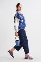 Person wearing a colorful jacket with a blue bag on a white background